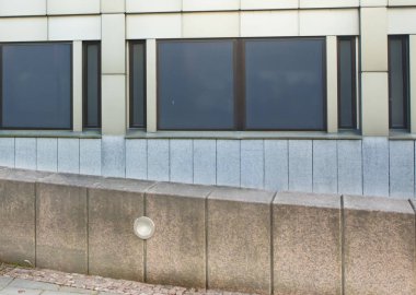 Şehir içinde siyah pencere eşiği ile geometrik modern duvar.