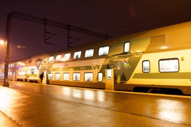 KOUVOLA, FINLAND - NOVEMBER 7, 2018: Train on the station at night, long exposure clipart