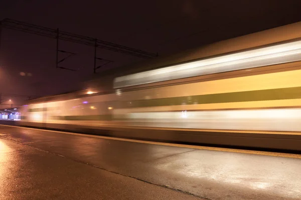 Train in motion on the station at night, long exposure photo