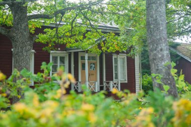 Kouvola, Finlandiya - 20 Eylül 2018: Güzel kırmızı eski ahşap ev ve büyük ağaç Anjala bölge manor üzerinde