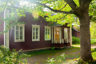 Kouvola, Finlandiya - 20 Eylül 2018: Güzel kırmızı eski ahşap ev ve büyük ağaç Anjala bölge manor üzerinde