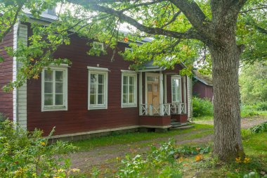 Kouvola, Finlandiya - 20 Eylül 2018: Güzel kırmızı eski ahşap ev ve büyük ağaç Anjala bölge manor üzerinde