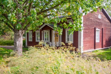 Kouvola, Finlandiya - 20 Eylül 2018: Güzel kırmızı eski ahşap ev ve büyük ağaç Anjala bölge manor üzerinde
