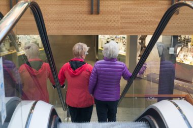 Kotka, Finlandiya - 27 Eylül 2018: Alışveriş merkezi Pasaati içinde yürüyen merdiven üzerinde iki kadın. Kasaba Finlandiya'nın Kymenlaakso bölgesinde bulunan.