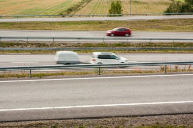 Bulanık arabalar hareket. Asfalt yollar Finlandiya'da sonbahar arabalı.