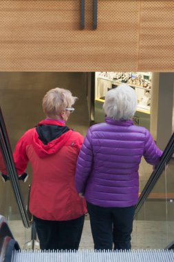 Kotka, Finlandiya - 27 Eylül 2018: Alışveriş merkezi Pasaati içinde yürüyen merdiven üzerinde iki kadın. Kasaba Finlandiya'nın Kymenlaakso bölgesinde bulunan.