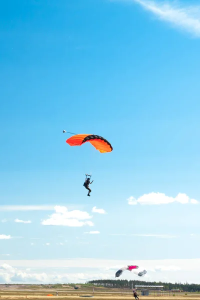 Two parachutists are landing on colorful parachutes to aerodrome. — Stock Photo, Image
