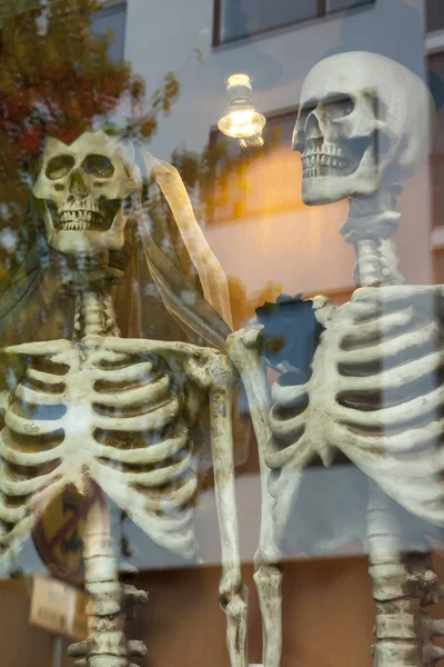 Two dressed up for honeymooners skeletons on the window. — Stock Photo, Image