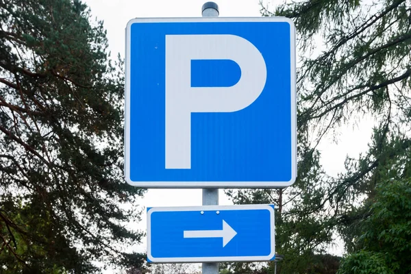 Parking sign with arrow in the park on sky and trees background. — Stock Photo, Image