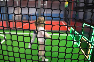 Bulanık çocuklar aktivite parkında kapalı oyun alanında net arkasında oynuyor.