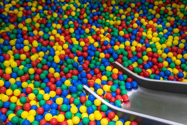 Glissière de bébé en métal descendant à la piscine avec de nombreuses boules colorées dans la salle de jeux pour enfants . — Photo