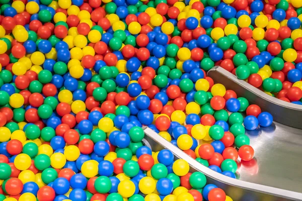 Glissière de bébé en métal descendant à la piscine avec de nombreuses boules colorées dans la salle de jeux pour enfants . — Photo