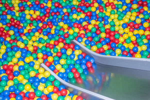 Glissière de bébé en métal descendant à la piscine avec de nombreuses boules colorées dans la salle de jeux pour enfants . — Photo