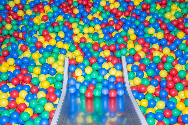 Glissière de bébé en métal descendant à la piscine avec de nombreuses boules colorées dans la salle de jeux pour enfants . — Photo