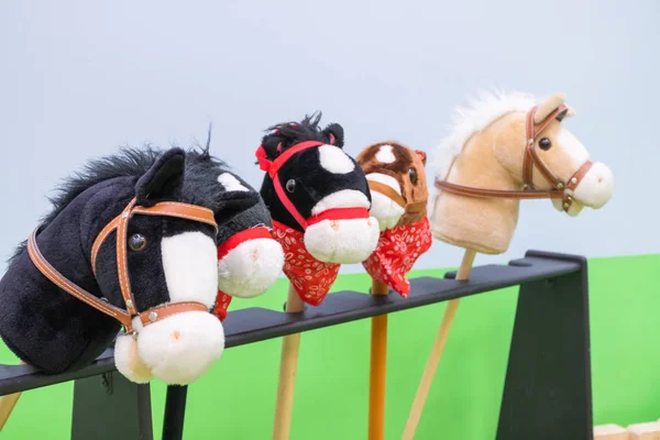 Row of multicolored hobbyhorses - children toys.