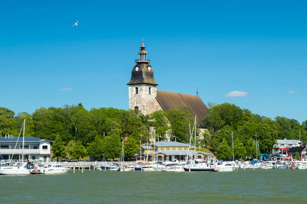 Naantali, Finlandiya - 28 Haziran 2019: Güneşli yaz gününde Naantali limanı ve ortaçağ taş kilisesi nin denizinden manzara, Finlandiya
