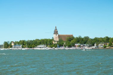 Naantali, Finlandiya - 28 Haziran 2019: Güneşli yaz gününde Naantali limanı ve ortaçağ taş kilisesi nin denizinden manzara, Finlandiya