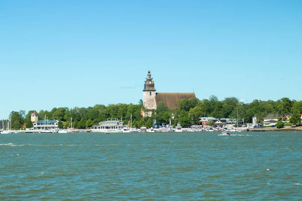 Naantali, Finnland - 28. Juni 2019: Blick vom Meer auf den Hafen von Naantali und die mittelalterliche Steinkirche an einem sonnigen Sommertag, Finnland — Stockfoto