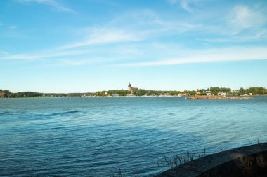 Naantali, Finlandiya - 28 Haziran 2019: Kultaranta'dan Naantali limanına ve güneşli yaz gününde ortaçağ taş kilisesine manzara.
