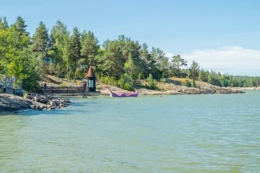 Naantali, Finlandiya - 28 Haziran 2019: Güneşli yaz gününde park Moominworld'de Yıkanan kulübe ve Edvard the Booble.