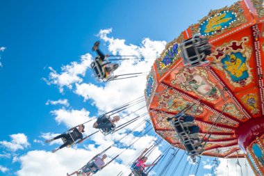 Tampere, Finlandiya-24 Haziran 2019: Ride Swing Carousel mavi gökyüzü arka planda eğlence parkı Sarkanniemi hareket içinde