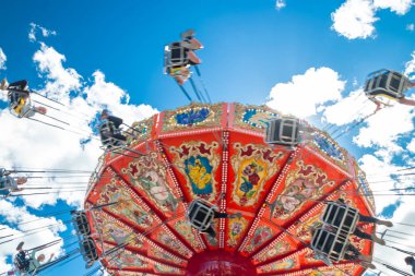 Tampere, Finlandiya-24 Haziran 2019: Ride Swing Carousel mavi gökyüzü arka planda eğlence parkı Sarkanniemi hareket içinde