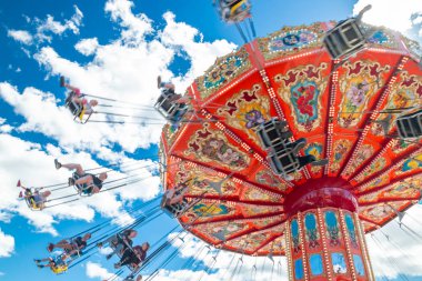 Tampere, Finlandiya-24 Haziran 2019: Ride Swing Carousel mavi gökyüzü arka planda eğlence parkı Sarkanniemi hareket içinde
