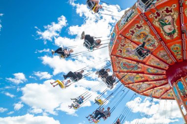 Tampere, Finlandiya-24 Haziran 2019: Ride Swing Carousel mavi gökyüzü arka planda eğlence parkı Sarkanniemi hareket içinde