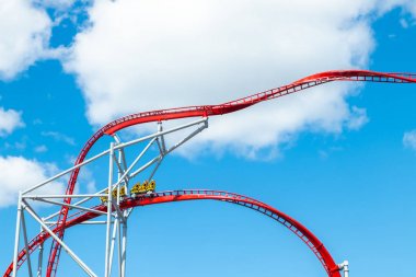 Mavi gökyüzü arka planda eğlence parkında roller coaster