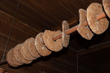 Rye bread drying on a pole. Traditional way to store bread in an farmhouse, hanging from a pole in the ceiling clipart