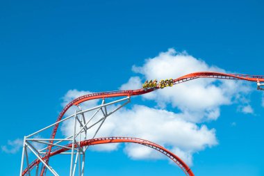 Mavi gökyüzü arka planda eğlence parkında roller coaster