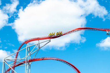 Mavi gökyüzü arka planda eğlence parkında roller coaster