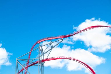 Mavi gökyüzü arka planda eğlence parkında roller coaster
