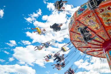 Tampere, Finlandiya-24 Haziran 2019: Ride Swing Carousel mavi gökyüzü arka planda eğlence parkı Sarkanniemi hareket içinde