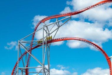 Mavi gökyüzü arka planda eğlence parkında roller coaster