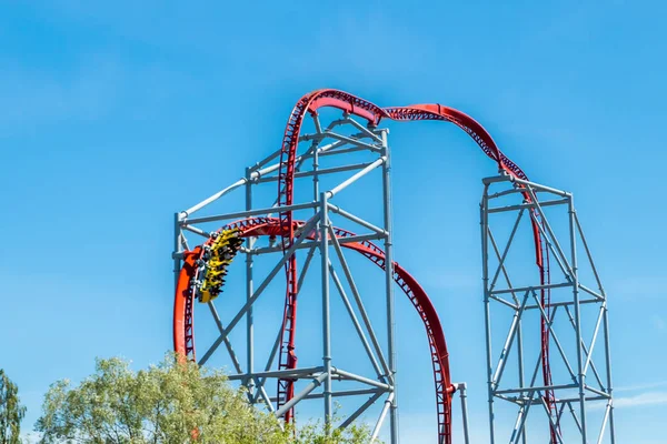 Mavi gökyüzü arka planda eğlence parkında roller coaster