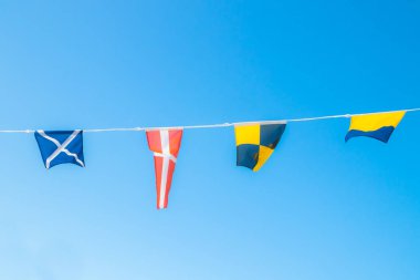 Mavi gökyüzüne karşı gemide Deniz bayrakları