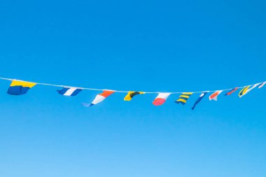 Mavi gökyüzüne karşı gemide Deniz bayrakları