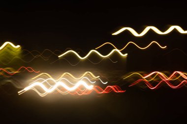 Siyah bir arka plan üzerinde bulanık renkli ışık etkisi Özet. Uzun pozlama fotoğraf hareketli kamera.