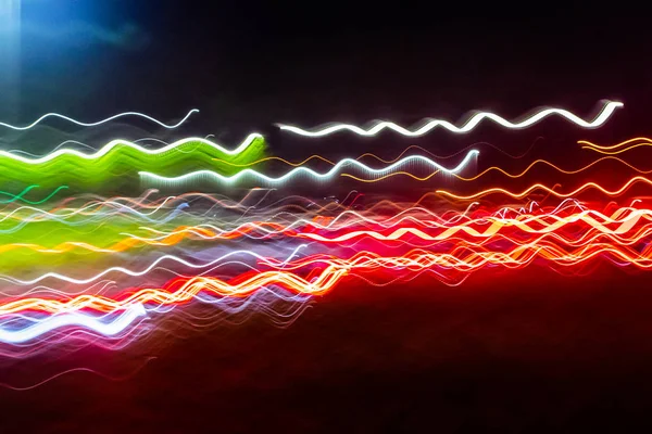 Siyah bir arka plan üzerinde bulanık renkli ışık etkisi Özet. Uzun pozlama fotoğraf hareketli kamera.