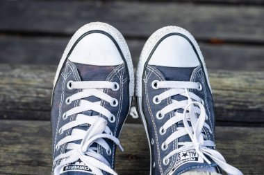 Kouvola, Finlandiya - 18 Ağustos 2019: Ahşap arka planda ayakları üzerinde mavi spor ayakkabılar. Üstte görüntü.