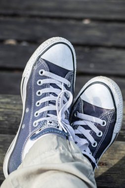 Kouvola, Finlandiya - 18 Ağustos 2019: Ahşap arka planda ayakları üzerinde mavi spor ayakkabılar. Üstte görüntü.