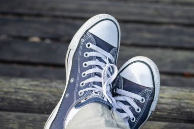 Kouvola, Finlandiya - 18 Ağustos 2019: Ahşap arka planda ayakları üzerinde mavi spor ayakkabılar. Üstte görüntü.