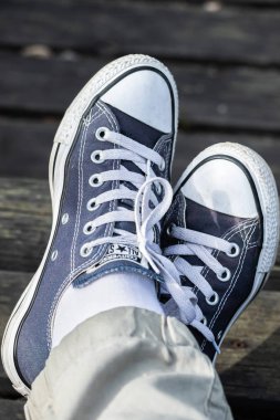 Kouvola, Finlandiya - 18 Ağustos 2019: Ahşap arka planda ayakları üzerinde mavi spor ayakkabılar. Üstte görüntü.