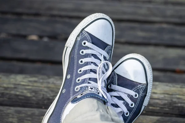 Kouvola, Finlandiya - 18 Ağustos 2019: Ahşap arka planda ayakları üzerinde mavi spor ayakkabılar. Üstte görüntü.