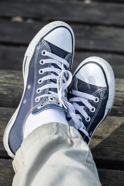 Kouvola, Finlandiya - 18 Ağustos 2019: Ahşap arka planda ayakları üzerinde mavi spor ayakkabılar. Üstte görüntü.