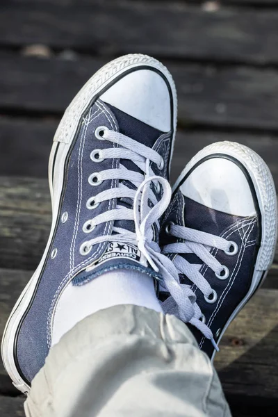 Kouvola, Finlandiya - 18 Ağustos 2019: Ahşap arka planda ayakları üzerinde mavi spor ayakkabılar. Üstte görüntü.