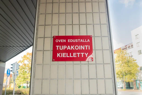 No smoking sign on the wall in Finnish language - No smoking in front of the door.