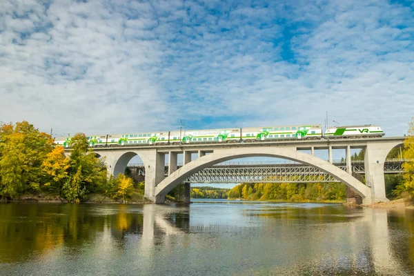 Kouvola, Finlandia - 25 settembre 2019: Paesaggio autunnale di ponte con treno passeggeri in movimento e acque del fiume Kymijoki in Finlandia, Kymenlaakso, Kouvola, Koria — Foto Stock