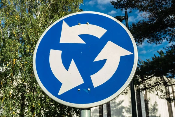 Roundabout road sign on blue sky and trees background — Stock Photo, Image